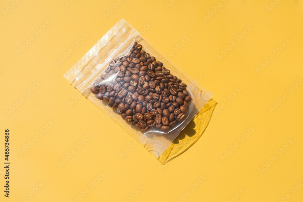 Roasted arabica coffee beans in blank transparent plastic bag with ...