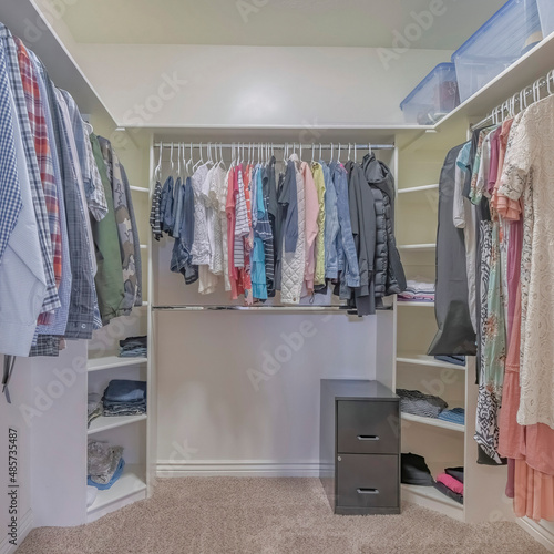 Square Interior of a walk in closet with shelving units and clothes