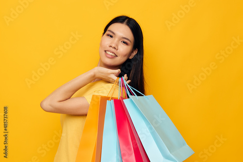 Portrait Asian beautiful young woman with packages in hands shopping isolated background unaltered