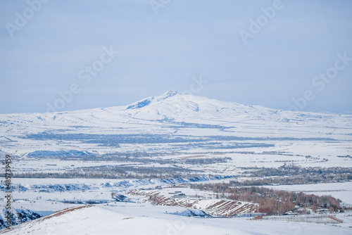 Snowy mountain peaks with a blue sky background. Spacious panorama of the winter landscape. The concept of frosty freshness, cold winter and snow-white cleanliness.