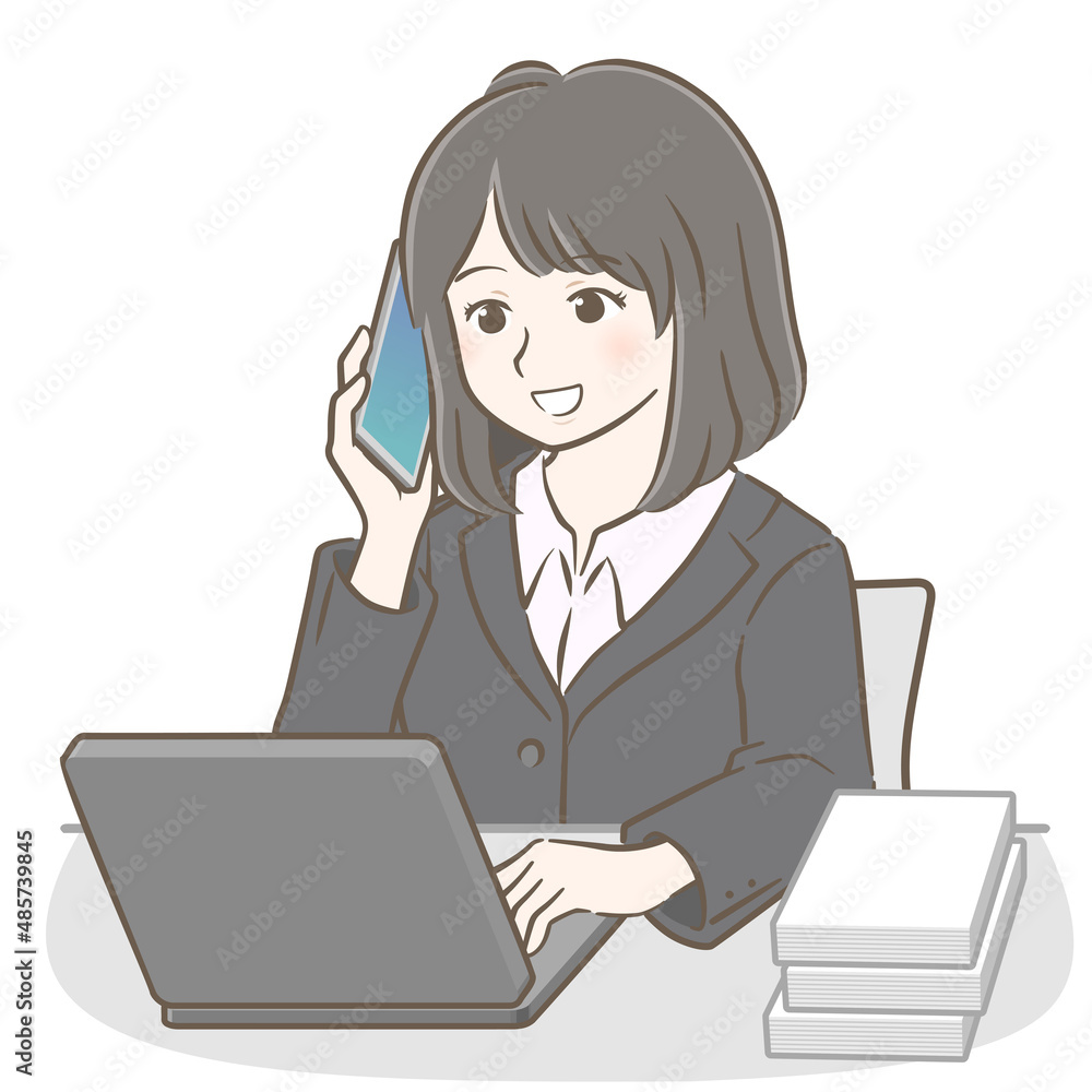 パソコンを操作しながら電話で話すスーツの若い女性 パソコンを操作しながら電話で話すスーツの若い女性