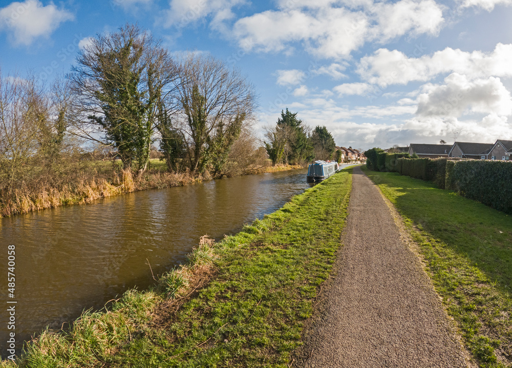 Narrowboat moored on a British canal in rural setting Narrowboat moored on a British canal in rural setting