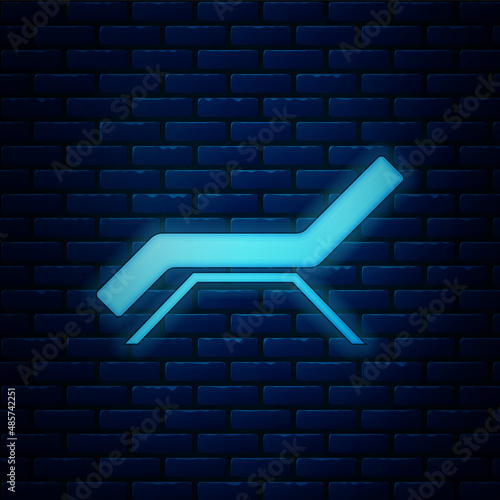 Glowing neon Sunbed icon isolated on brick wall background. Sun lounger. Vector