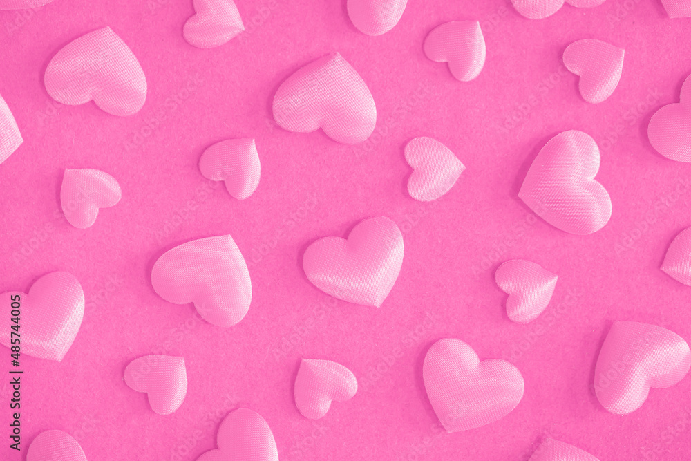Background from hearts and sparkles. Pink hearts on a pink background top view. Background for love flat lay. The concept of a holiday, miracles and surprises.