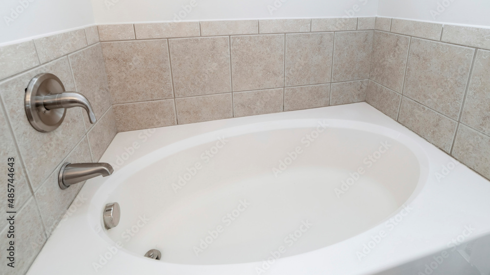 Panorama Alcove bathtub with gray tiles surround and wall mounted stainless faucet fixtures Panorama Alcove bathtub with gray tiles surround and wall mounted stainless faucet fixtures