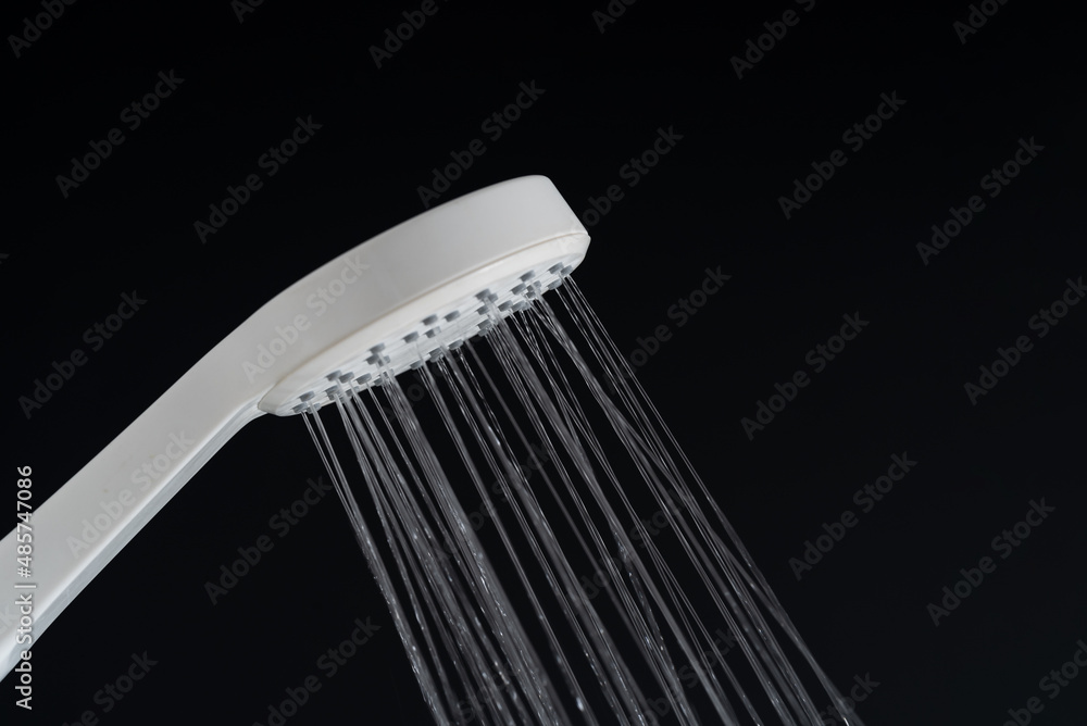 Water pouring from white shower head. Water pouring from white shower head.