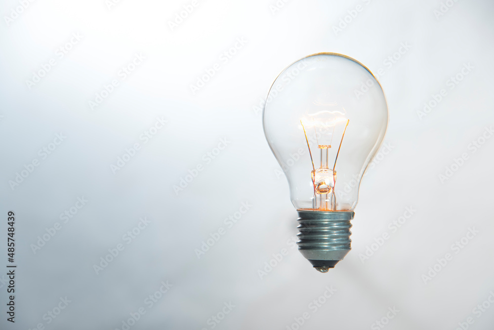 tungsten light bulb lit on blue background