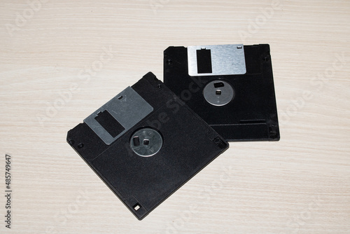 Two floppy disks on a wooden table