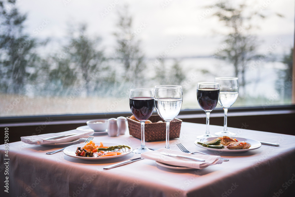 Delicious dinner table set up with red wine at a restaurant with amazing views, Ushuaia, Tierra del Fuego, Patagonia, Argentina, South America