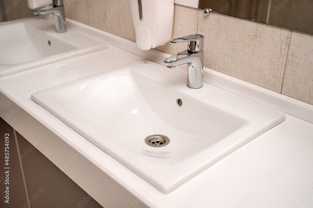 Public sinks, Handwashers for people using public toilets, Cleaning after using the toilet service, Public toilets and hygiene concept. Public sinks, Handwashers for people using public toilets, Cleaning after using the toilet service, Public toilets and hygiene concept.