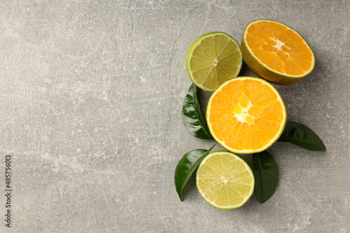 Citrus fruits on gray textured background, space for text