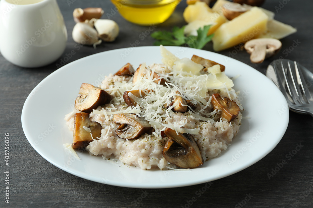Concept of tasty food with risotto with mushrooms on dark wooden table Concept of tasty food with risotto with mushrooms on dark wooden table