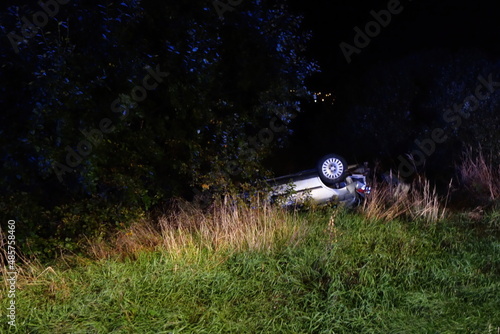 Real event. Car accident. The car crashed at night on a wet road and overturned . Car accident over raining day in autumn time. Rescuers help with car accident, ambulance, fire and police.