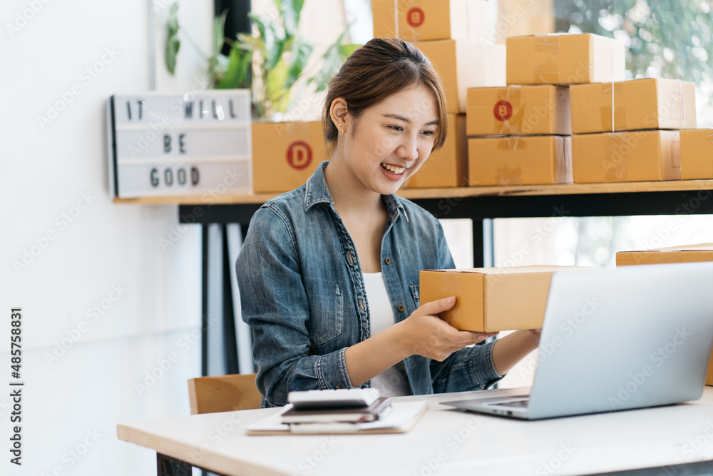 Small Business SME entrepreneur of Young Asian women working with laptop for Online shopping at home,Cheerful and Happy with box for packaging in home,Own Business Start up for Business Online Small Business SME entrepreneur of Young Asian women working with laptop for Online shopping at home,Cheerful and Happy with box for packaging in home,Own Business Start up for Business Online