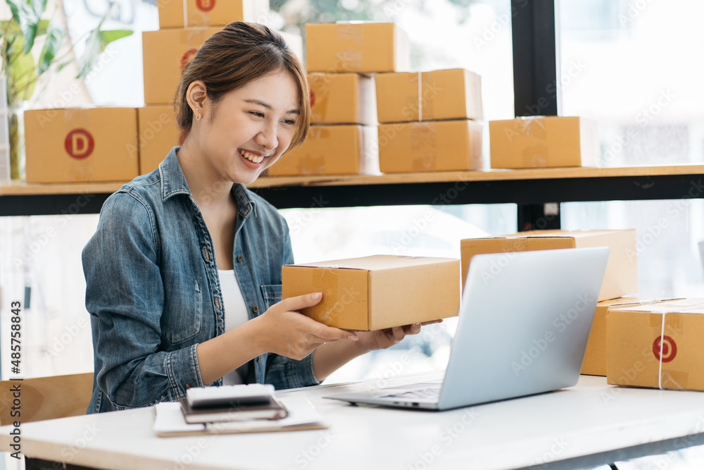 Small Business SME entrepreneur of Young Asian women working with laptop for Online shopping at home,Cheerful and Happy with box for packaging in home,Own Business Start up for Business Online Small Business SME entrepreneur of Young Asian women working with laptop for Online shopping at home,Cheerful and Happy with box for packaging in home,Own Business Start up for Business Online