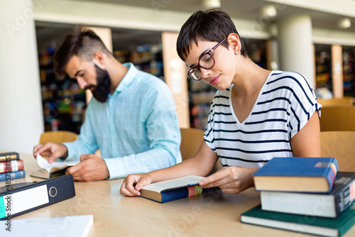 Happy group of students studying and working together in a college library