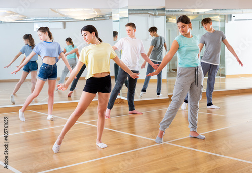 Fototapeta Naklejka Na Ścianę i Meble -  Dancing group of five teenagers practicing new dance in studio