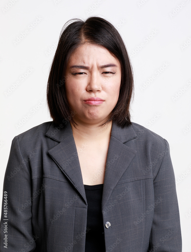 Portrait studio isolated cutout closeup head shot of Asian young moody sad upset unhappy stressed depressed frowning face female businesswoman in formal suit jacket look at camera on white background