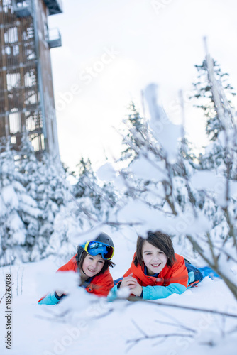 Happy preteen children on ski slope, enjoying snow