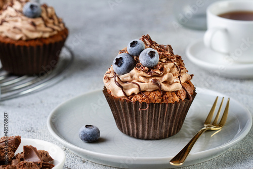 Chocolate cupcake with blueberries on a plate