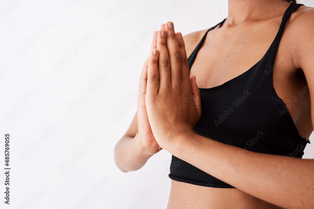 Peace is a yoga session away. Shot of an unrecognizable woman posing with her hands clasped against a white background.