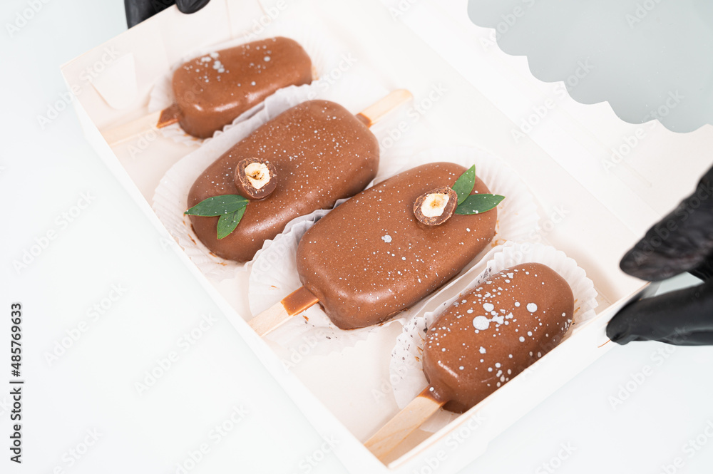 Box with chocolate cake pops in the form of ice cream on a stick. Concept food, sweets. Box with chocolate cake pops in the form of ice cream on a stick. Concept food, sweets.