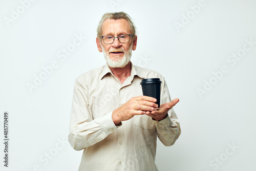 Portrait elderly man in a shirt and glasses a black glass isolated background © Tatiana