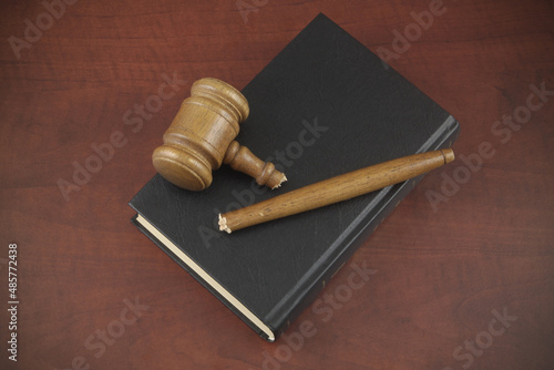 Fotografie Broken wooden judge gavel on black legal book
