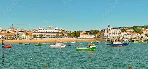 Panoramic view of sandy bay from city - Cascais, portuguese coast at Atlantic. Fishing boat with fishing net and equipment  