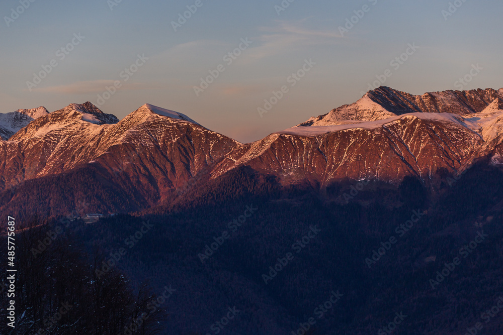 View of snow-capped mountains in delicate pastel purple shades after sunset