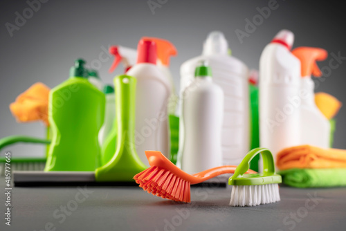 House  and office cleaning products. White and green cleaning kit on gray background.