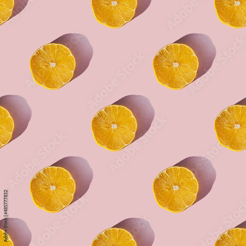 Leinwand Poster Uniform pattern of dried lemon slices with shadow on a pink background