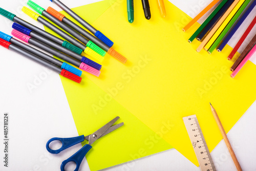 Set of color papers, scissors, ruler, felt-tip pens and pencil for creative work on white background. Top view. Flatlay