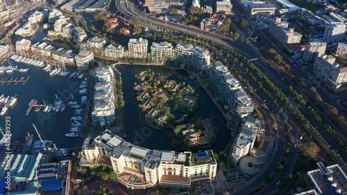 Aerial shot orbiting around a man-made island in the marina district of Cape Town