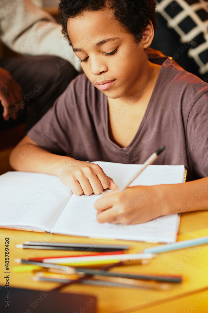 Smart African boy doing his math homework with a little help of his grandpa. Tutoring and education Smart African boy doing his math homework with a little help of his grandpa. Tutoring and education
