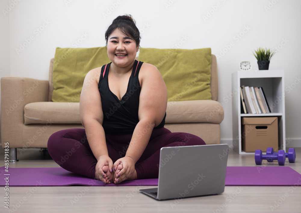 Attractive asian young fitness woman plus size stretching legs warming up before workout at home. Beautiful smiling Female wearing sportswear exercise training yoga in living room. Attractive asian young fitness woman plus size stretching legs warming up before workout at home. Beautiful smiling Female wearing sportswear exercise training yoga in living room.