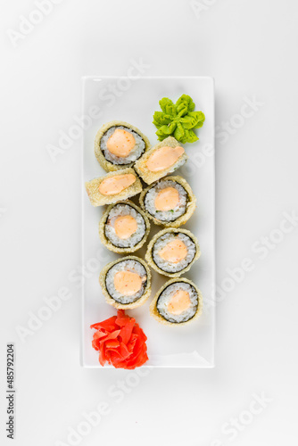 Japanese tempura hot sushi roll on white plate and background. Sushi pieces with cream cheese, wrapped in rice.