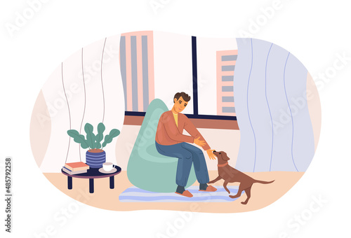 Man playing with lovely dog sitting on armchair at cozy home. Love friendship between puppy and men