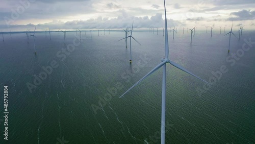 Drone video of enormous windmills stand in the sea along a dutch sea. Fryslân wind farm, the largest inland wind farm in the world. Friesland, Afsluitdiijk, Ijsselmeer, Breezanddijk, Netherlands