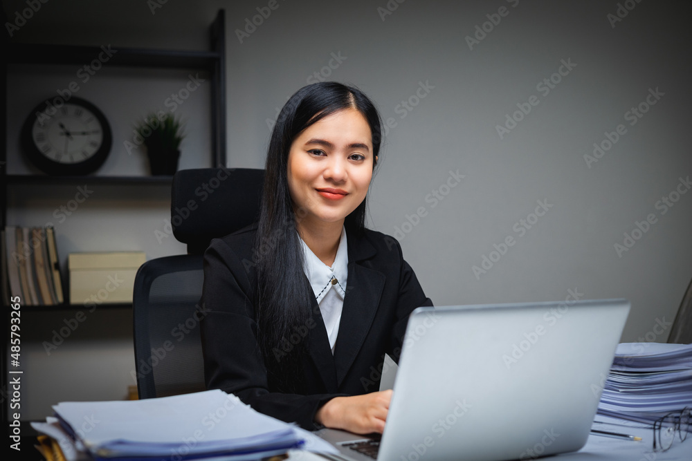 Lovely asian business woman working with laptop at night. Attractive female in suit work late at night overtime sitting in the dark room office. Lovely asian business woman working with laptop at night. Attractive female in suit work late at night overtime sitting in the dark room office.