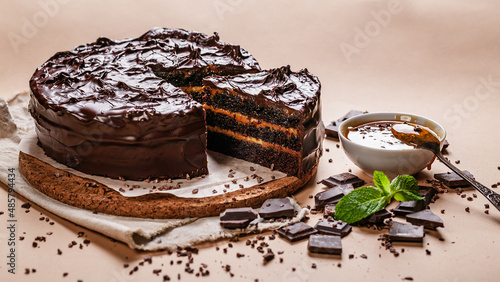 Food banner. Chocolate cake with salted caramel on a beige background. Homemade delicious pastries. Sweet dessert.