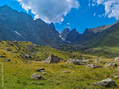 A panoramic view on the sharp mountain peaks of the Chaukhi massif in the Greater Caucasus Mountain Range in Georgia, Kazbegi Region. The valley is full of the Roshka stones. Georgian Dolomites.