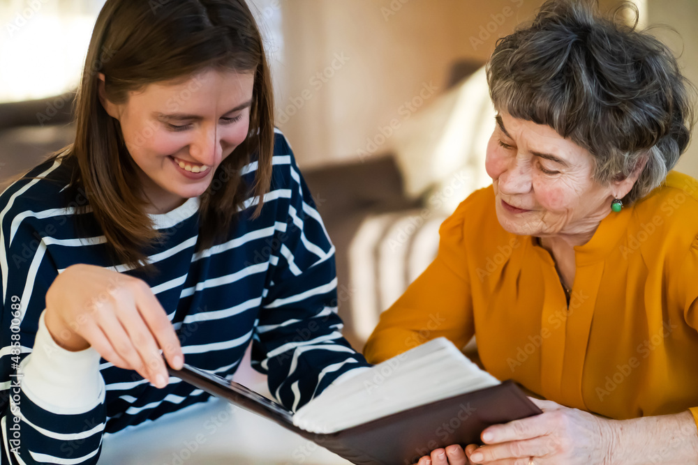Old woman with her granddaughter look at family photos. Old woman with her granddaughter look at family photos.