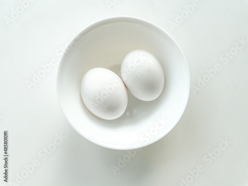 White egg in the white bowl isolated on white background. Protein for eating.