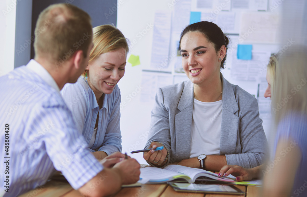 Fototapeta premium Young people studying with books on desk. Beautiful women and men working together.