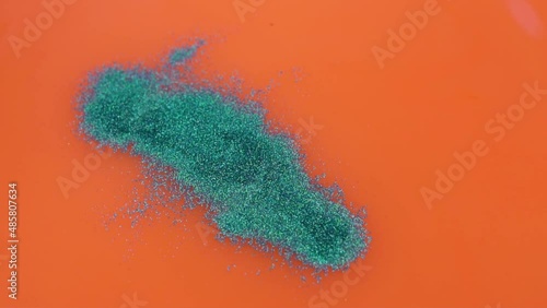 Wallpaper Mural Blue Glitters Pour into Orange Water Forming Patterns on Water, Slow Motion. Orange Fluid Surface with Blue Glitters, Orange Background with Patterned Paints. Torontodigital.ca