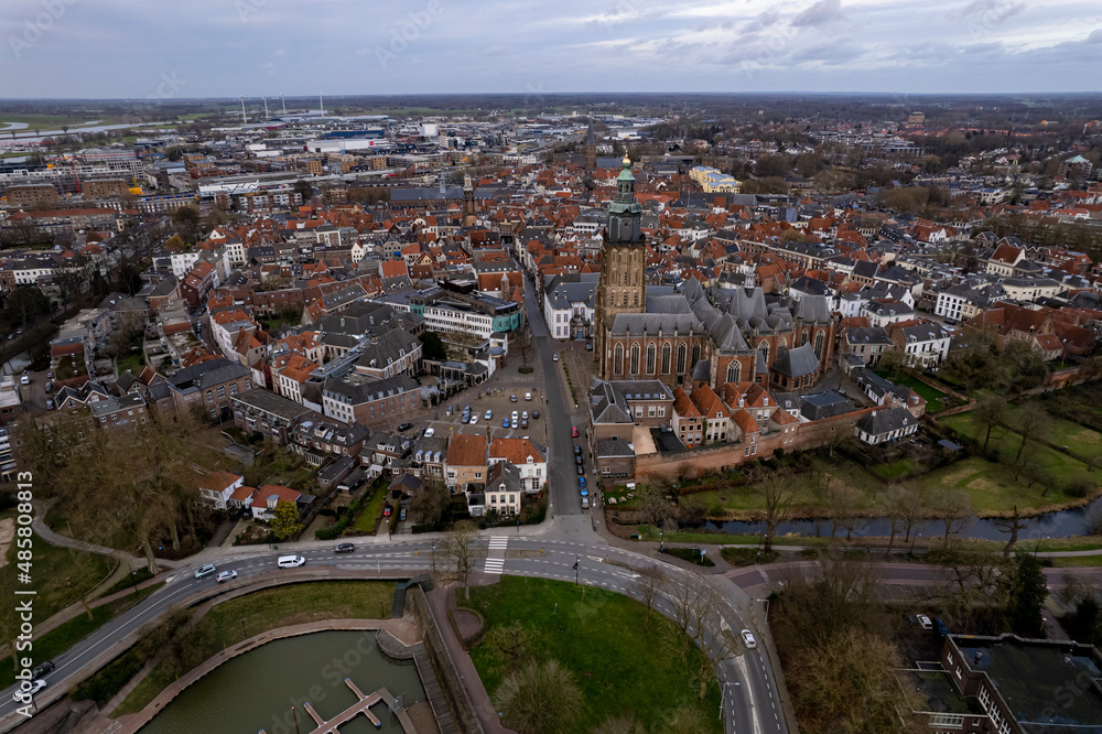 Obraz premium Picturesque aerial view of tower town Zutphen in The Netherlands with medieval Hanseatic city center on the river IJssel and highlighted Walburgiskerk. Panorama of Dutch settlement seen from above.