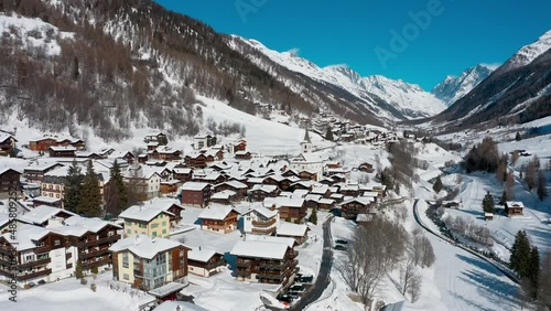 Village de montagne dans une vallée enneigée des Alpes suisses. Vues aériennes.