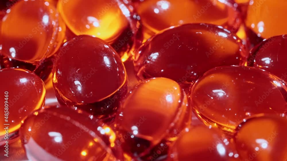 Macro shot of a red oil capsules, Vitamin C, Omega 3 rotating closeup. Pills and drugs. Pharmaceutical Industry. The medicine concept. Slow motion. High quality 4k footage Macro shot of a red oil capsules, Vitamin C, Omega 3 rotating closeup. Pills and drugs. Pharmaceutical Industry. The medicine concept. Slow motion. High quality 4k footage