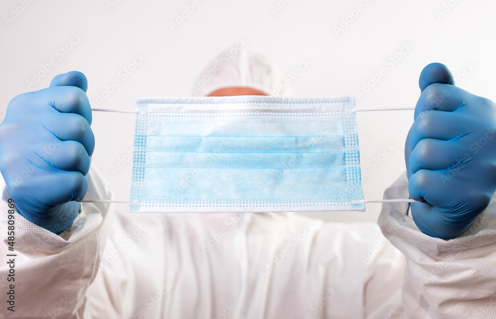 Close up of doctor hand holding surgical face mask Close up of doctor hand holding surgical face mask